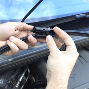 Manos mostrando pieza del limpiaparabrisas Anclaje de escobilla